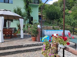 a patio with a table and chairs and flowers at Pensiunea Ana in Cavnic