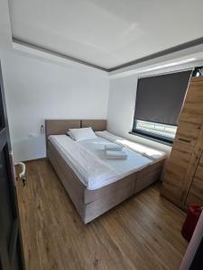 a bedroom with a large bed and a window at Sia Lake View Bicaz in Ceahlău