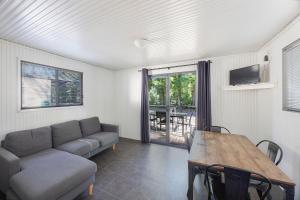 タマットにあるReflections Tumut Riverのソファとテーブルのあるリビングルーム