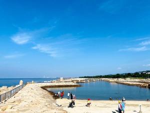 a group of people on a beach near the water at Hannan Village fourth in Hannan +21 photos