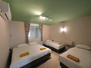 a hotel room with two beds and a window at 財家 Chai House NEAR Lee Garden,Private parking in Hat Yai