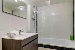 un bagno bianco con lavandino e doccia di Le nid douillet - Centre Ville - 3 étoiles a Bourg-en-Bresse
