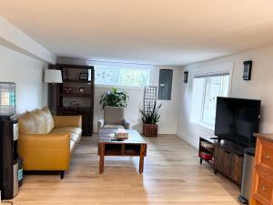 ein Wohnzimmer mit Sofa und Fernseher in der Unterkunft Newly renovated 2-bedroom, 1-bathroom suite with private entrance in West Kelowna