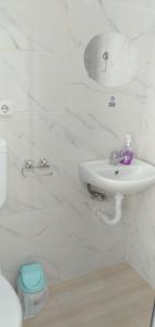 a white bathroom with a sink and a toilet at GEYİKLİ BULUT Pansiyon in Ezine