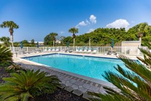 a swimming pool with chairs and palm trees at 140 Feet To White Sandy Beaches! Newly Renovated! Pool! Grill! in Laguna Beach