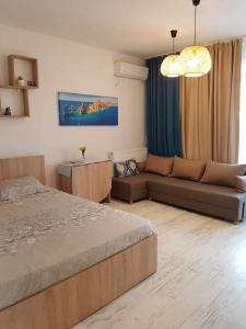 ein Wohnzimmer mit einem Bett und einer Couch in der Unterkunft Saturn SunRise Studio in Saturn