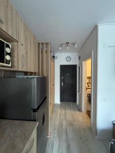 eine Küche mit Holzschränken und einer schwarzen Tür in der Unterkunft Saturn SunRise Studio in Saturn