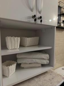ein Regal mit Handtüchern und Körben darauf in einem Badezimmer in der Unterkunft Saturn SunRise Studio in Saturn + 20 Fotos