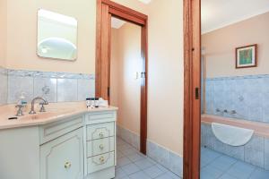 un baño con lavabo y bañera en Encounter Bay Family Retreat, en Encounter Bay 38 fotos más
