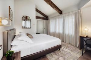 una camera da letto con un grande letto bianco e una finestra di Hotel Carlton a Treviso