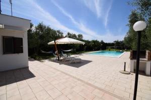 a patio with an umbrella and a swimming pool at Villa MEMA in Bisceglie +46 photos