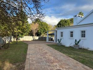 a brick driveway leading to a white house at The Blossom Room in Robertson
