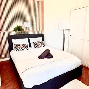 a bedroom with a large bed with white sheets and pillows at Modern Home proche de Disneyland et Paris in Champs-Sur-Marne