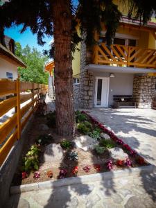 a tree with flowers in front of a building at Liliana Apartman és Csónakház in Badacsonytomaj
