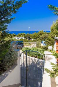 a gate to a driveway with the ocean in the background at Apartments Gordana in Primošten
