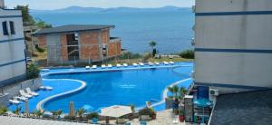 a large swimming pool with a view of the ocean at Divine place Pomorie in Pomorie