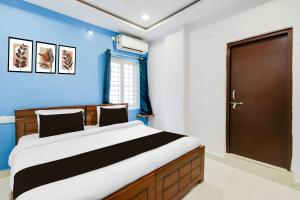 a bedroom with a large bed with a blue wall at Super Townhouse Hitech City Madhapur in Hyderabad