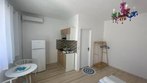 a small kitchen with a white refrigerator and a table at PAGONI apartments in Kardamaina