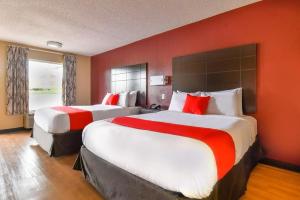 duas camas num quarto de hotel com paredes vermelhas em OYO Hotel Tyler Northwest Mineola Hwy em Tyler mais 154 fotografias