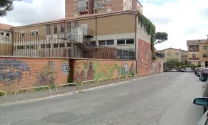 a street with graffiti on the side of a building at B&B Salviani in Acilia