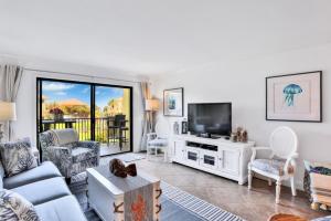 a living room with a couch and a tv at Summerhouse 147 in St. Augustine