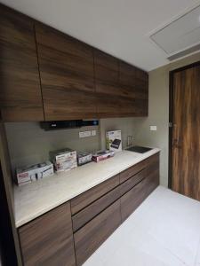 a kitchen with wooden cabinets and a counter top at The Luxury Studio in Gurgaon +2 photos