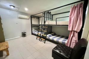 a room with two bunk beds and a chair at Orchid Hostel in Bangkok