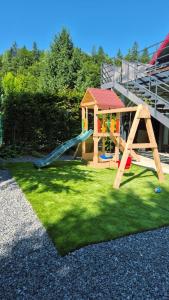 un parque infantil con tobogán y una casa de juegos en Vila Dani&Marina, en Porumbacu de Sus