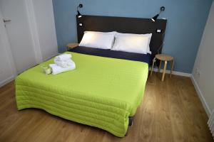 a bedroom with a green bed with towels on it at La Casa Ritrovata in Marcheno