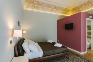 カターニアにあるMungibeddu Organic Bed and Breakfastの赤い壁のホテルルーム
