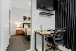 una camera con scrivania e una camera con un letto di Emerald Inn by Travellers a Emerald