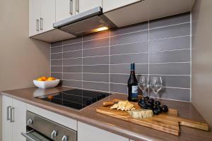una cucina con un bancone con una bottiglia di vino e bicchieri da vino di Emerald Inn by Travellers a Emerald