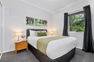 una camera da letto con un letto grande e una finestra di Emerald Inn by Travellers a Emerald