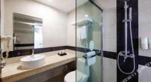 a bathroom with a sink and a toilet and a shower at GreenTree Alliance Ningbo South Train Station Shunde Road Hotel in Ningbo +132 photos