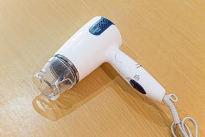 横浜市にある元町翡翠ビルの木製テーブルの上に白い電気式ヘアドライヤー