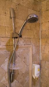 a shower in a stone wall with a shower head at Alacati Sardunya Hotel in Alaçatı