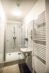 a bathroom with a glass shower and a sink at Ahoy! Hostel in Prague +37 photos