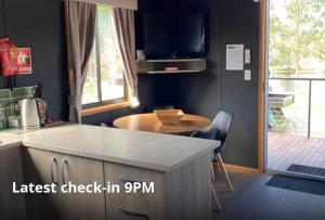 斯托尔Stawell Grampians Gate C & C Park的厨房配有柜台、桌子和电视。