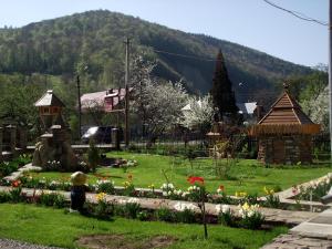 a person standing in a garden with flowers at Guest House U Myrona in Yaremche