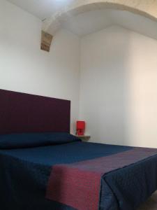 カステッランマーレ・デル・ゴルフォにあるI due Archiの白い部屋に青いベッドが備わるベッドルーム1室