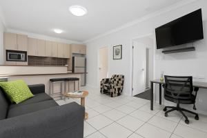 un soggiorno con un divano, un tavolo e una cucina di Emerald Inn by Travellers a Emerald