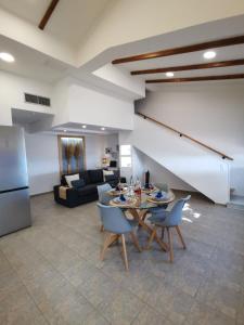 a living room with a table and chairs and a couch at Alexandra's Sea Front Villa in Pefki +34 photos