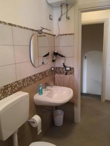 bagno con lavandino, servizi igienici e specchio di I due Archi a Castellammare del Golfo