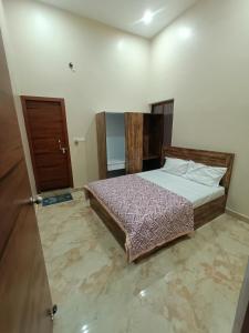 Rāe BareliにあるHotel Shree Mayakunjのベッドルーム1室(ベッド1台付)、木製のドア