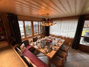 a dining room with a table and chairs and a chandelier at Le Pacheu in Les Crosets