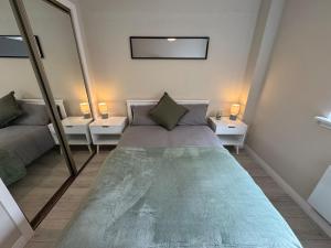 Un dormitorio pequeño con una cama y dos espejos. en Newly Renovated Flat Edinburgh - 2 x Double Beds, en Edimburgo 3 fotos más