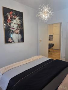 a bedroom with a bed and a painting on the wall at Apartament Kwiatowy DeLux in Sanok