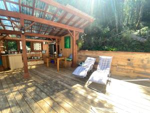 two chairs and a table on a wooden deck at Tree Top Sanctuary Cowichan Valley in Duncan