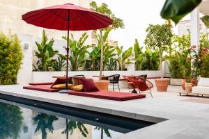 a patio with chairs and an umbrella next to a pool at Palazzo Piccinno in Parabita