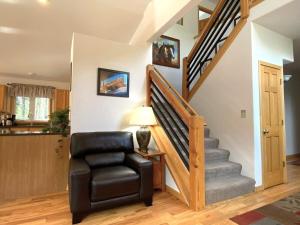 a living room with a chair and a staircase at Echo Hills Mountain Lodge - Evergreen Mountain Top Retreat - Foothills of the Rockies in Evergreen
